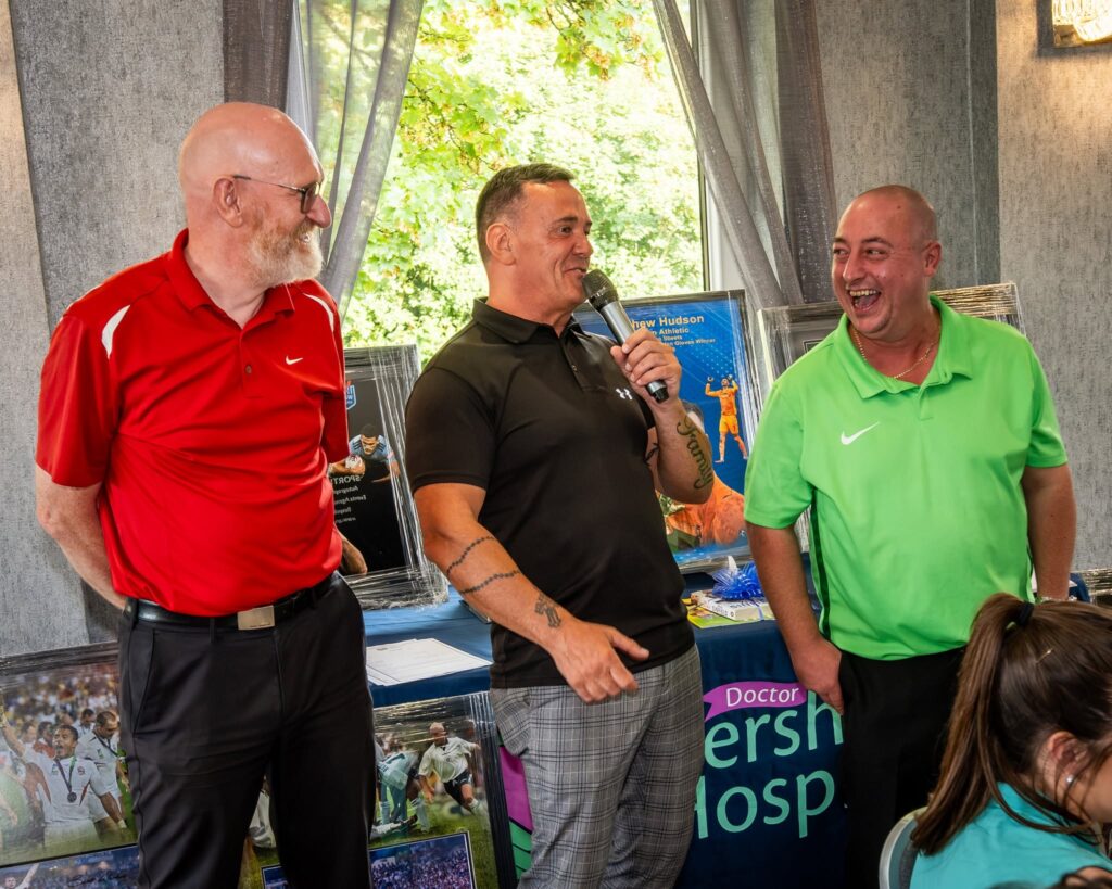 Three men laughing and joking inside the event