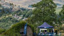A Dr Kershaw's Hospice tent in front of a huge expanse of countryside and trees