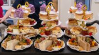 A table of afternoon tea, including cakes and sandwiches