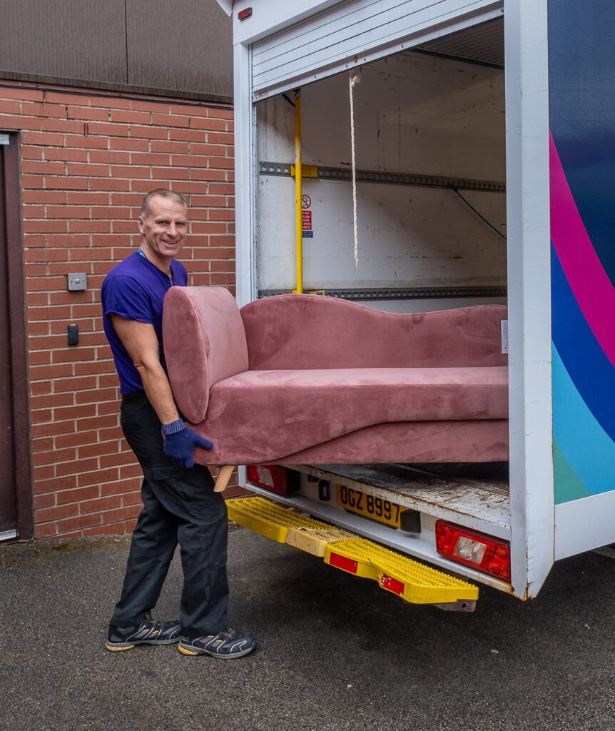 Friendly Furniture Hub collection driver loading a sofa into a van
