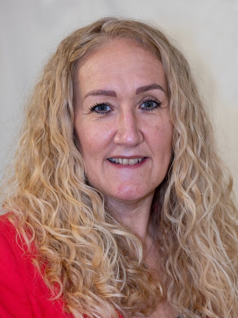 Woman with curly blonde hair smiling