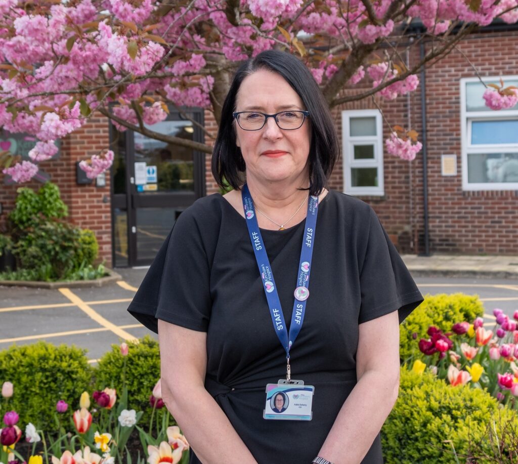 CEO Adele Doherty stood in front of a cherry blossom tree