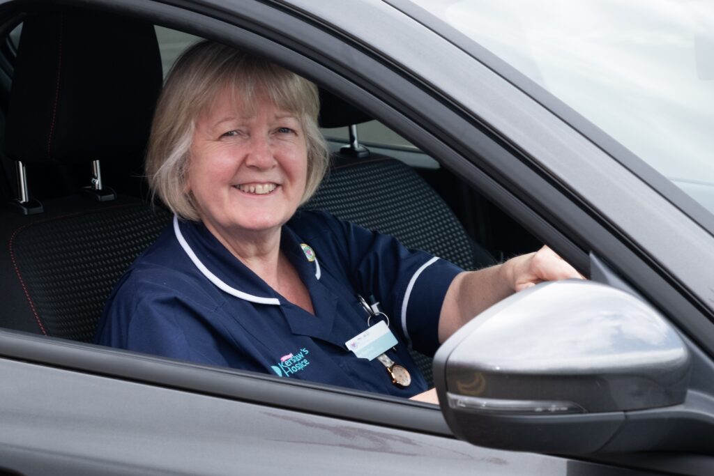 Female nurse smiling inside a car