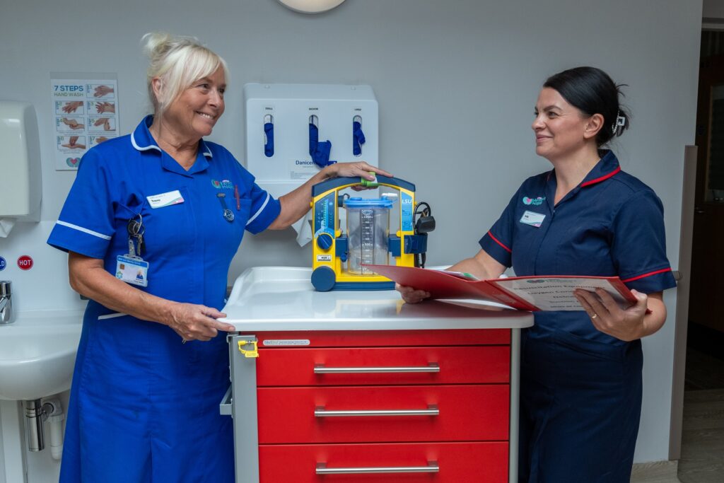 Two nurses smiling in a medical store room