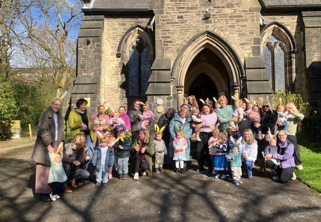 Children wearing bunny ears with their parents and carers outside a church
