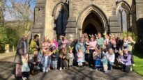 Children wearing bunny ears with their parents and carers outside a church