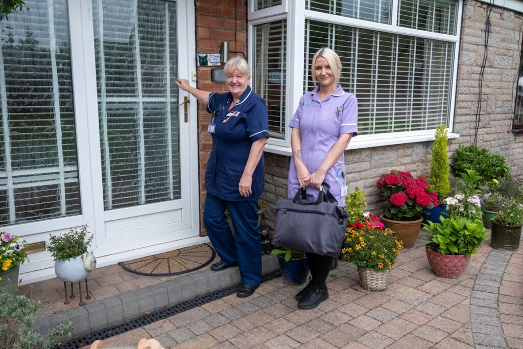 A nurse and healthcare assistant knocking on a door