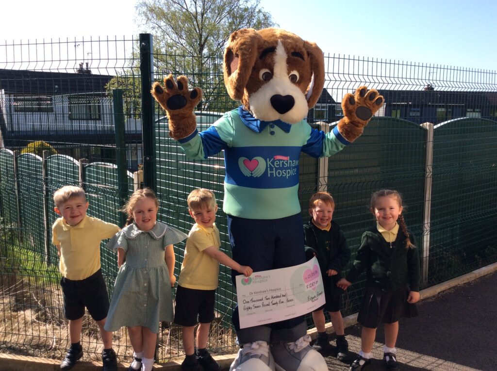 Hartley the mascot with school children and a cheque for £1,287