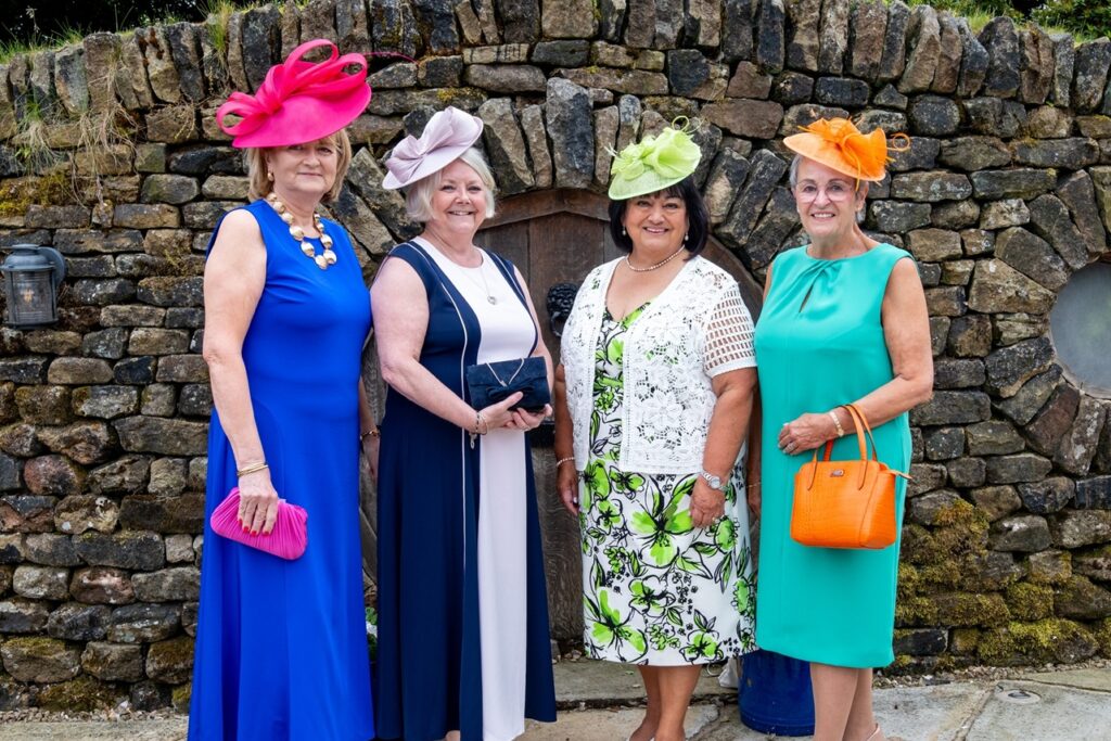 Women in colourful dresses and hats standing outside