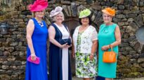 Women in colourful dresses and hats standing outside