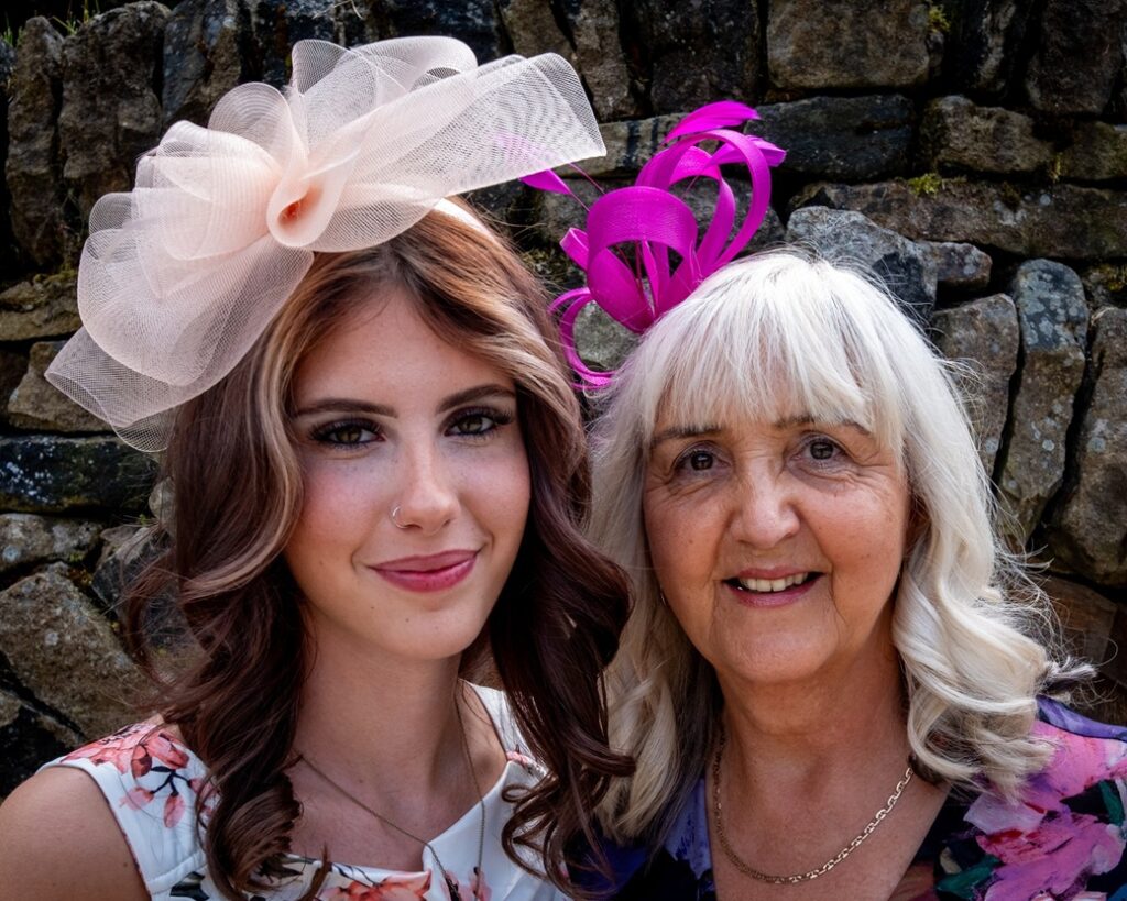 Two ladies wearing purple and pink hats