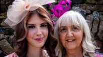 Two ladies wearing purple and pink hats