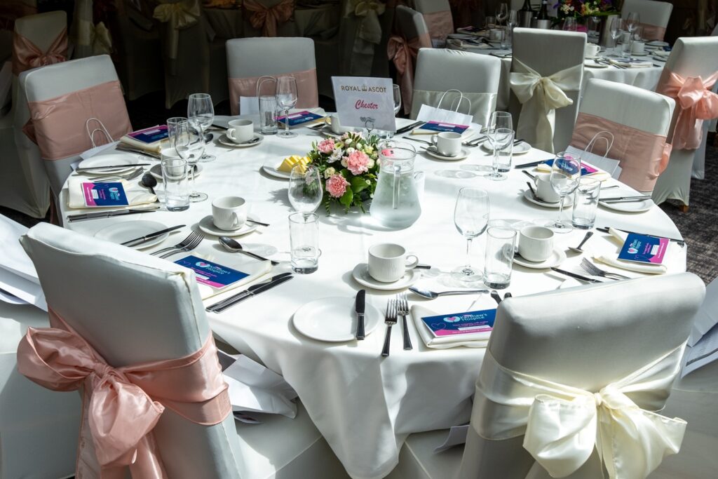 A beautifully decorated white table with chairs adorned in bows