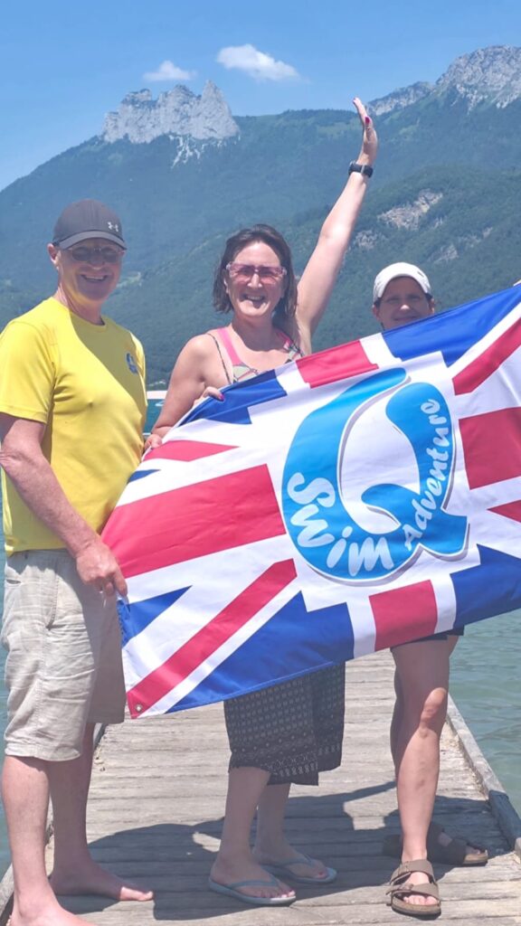 Woman holding up a flag near a lake